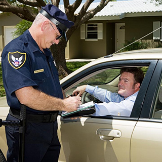 A police officer speaking to a man in a car